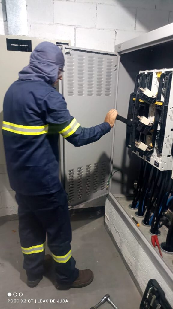 Eletricista fechando o painel do centro de medição após manutenção preventiva